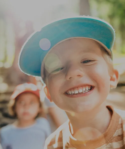 young boy with blue hat on playing outside - North Jersey Dental Group