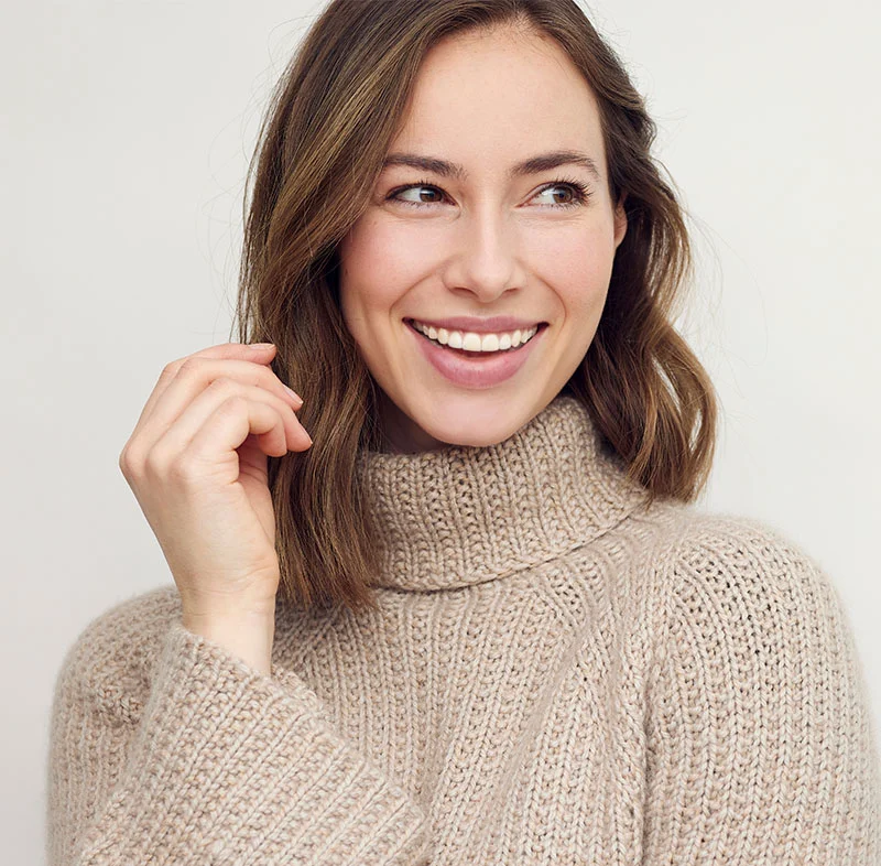 woman with short brown hair wearing beige turtle neck sweater smiling - North Jersey Dental Group